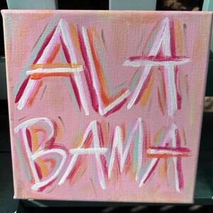 Peut inclure: Une peinture sur toile carr&eacute;e avec un fond rose clair pr&eacute;sentant le mot ALABAMA peint &agrave; la main dans un style expressif et superpos&eacute;. Les lettres sont r&eacute;alis&eacute;es avec des traits superpos&eacute;s de peinture blanche, rose vif et orange textur&eacute;e.