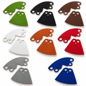 Puede incluir: Una colección de ocho juegos de capas en miniatura en varios colores, incluyendo verde, negro, marrón, blanco, naranja, rojo, gris y azul. Cada juego consta de una pieza de cuello curva con recortes circulares y una pieza de capa trapezoidal.