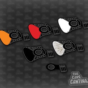 Puede incluir: Cinco cubiertas de luz de diferentes colores para una luminaria con temática de Star Wars. Las cubiertas son naranja, roja, blanca, negra y con un patrón de veta de madera. Las cubiertas tienen todas la misma forma y tienen un marco negro alrededor. El texto "The Cape Cantina" está en la esquina inferior derecha de la imagen.