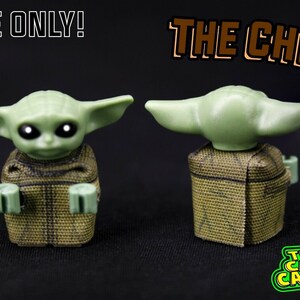 Puede incluir: Una minifigura Lego verde de "The Child" de Star Wars: The Mandalorian, con una capa de camuflaje marr&oacute;n y verde. La figura se muestra de frente y de espalda. El texto "CAPE ONLY!" y "THE CHILD" es visible en la imagen.