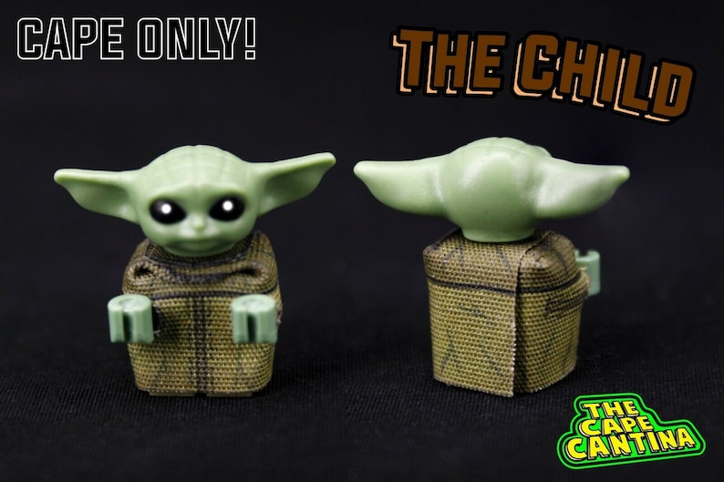 Puede incluir: Una minifigura Lego verde de "The Child" de Star Wars: The Mandalorian, con una capa de camuflaje marr&oacute;n y verde. La figura se muestra de frente y de espalda. El texto "CAPE ONLY!" y "THE CHILD" es visible en la imagen.