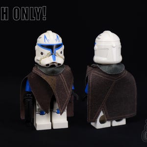 May include: A brown cloth cape for a Star Wars Clone Trooper action figure. The cape is made of a soft, textured fabric and has a simple design. The figure is not included.
