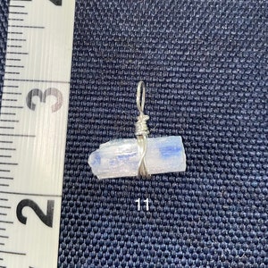 Peut inclure: Un pendentif en fil d'argent enroul&eacute; autour d'un cristal de s&eacute;l&eacute;nite bleu clair. Le cristal mesure environ 2,5 cm de long.