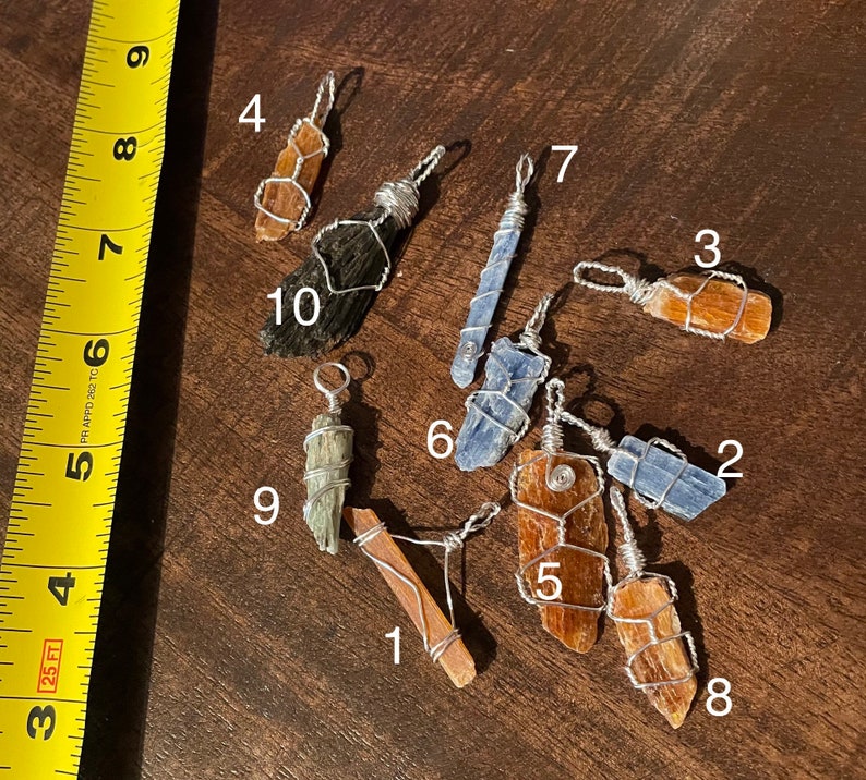 Peut inclure: Dix pendentifs en cristal envelopp&eacute;s de fil, dont du kyanite bleu, de la s&eacute;l&eacute;nite brune et de la s&eacute;l&eacute;nite orange. Les pendentifs sont num&eacute;rot&eacute;s de 1 &agrave; 10.