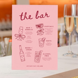 May include: A pink bar menu with the words "the bar" in cursive. The menu lists wine, cocktails, beers, shots, and alcohol-free drinks with illustrations. Two champagne flutes filled with a golden liquid are in the background.