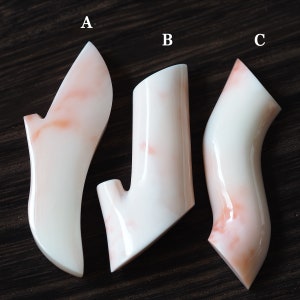 May include: Three white ceramic vases with a pink marbled pattern. The vases are in different shapes and sizes. The vases are labeled A, B, and C.
