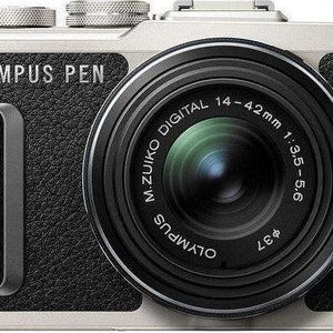 Puede incluir: Una cámara Olympus PEN plateada con cuerpo de cuero negro y lente M.ZUIKO DIGITAL 14-42mm 1:3.5-5.6 negro.