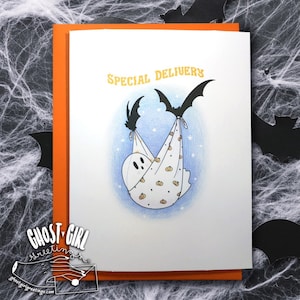 Puede incluir: Un fantasma blanco con una cara amigable est&aacute; envuelto en una manta azul y blanca con un patr&oacute;n de calabaza. Dos murci&eacute;lagos negros sostienen la manta, como si estuvieran entregando al fantasma. La tarjeta dice "Entrega especial".