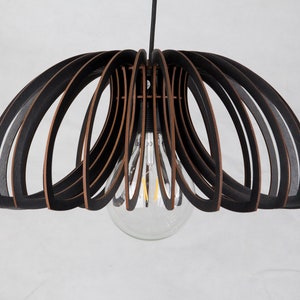 May include: Black and brown wooden pendant light fixture with a circular shape and a single light bulb.