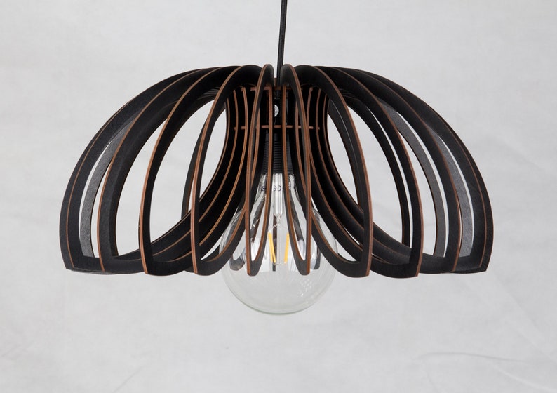 May include: Black and brown wooden pendant light fixture with a circular shape and a single light bulb.