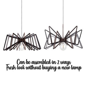 May include: A modern pendant light fixture with a geometric design. The light fixture is made of black and copper metal and can be assembled in two different ways. The text "Can be assembled in 2 ways Fresh look without buying a new lamp" is displayed below the image.
