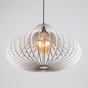 Puede incluir: L&aacute;mpara colgante blanca con un dise&ntilde;o geom&eacute;trico. La l&aacute;mpara est&aacute; hecha de madera y tiene una forma circular. La l&aacute;mpara est&aacute; colgada de un cable negro.