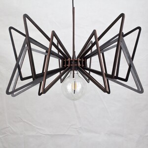 May include: A modern black and copper pendant light fixture with a geometric design. The light fixture is made of multiple triangular shapes and features a single light bulb.