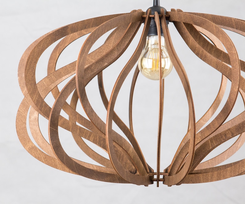 Op de afbeelding: Een houten hanglamp met een geometrisch ontwerp. De lamp is gemaakt van dunne stroken hout die met elkaar zijn verweven om een unieke en moderne uitstraling te cre&euml;ren. De lamp is voorzien van een gloeilamp.