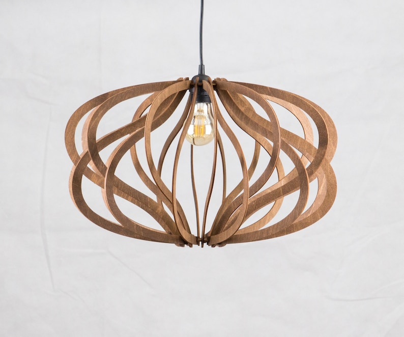 Op de afbeelding: Een houten hanglamp met een uniek, golvend ontwerp. De lamp is gemaakt van natuurlijk hout en heeft een warme, uitnodigende uitstraling.