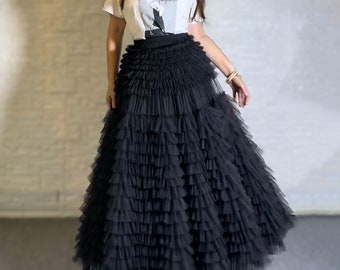 May include: A black tulle skirt with multiple layers of ruffles. The skirt is long and flowy, and it would be perfect for a special occasion.