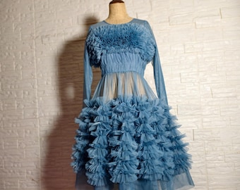 May include: A blue tulle dress with a ruffled bodice and skirt. The dress is on a mannequin and has long sleeves.