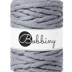 May include: A skein of light gray cotton rope yarn with the brand name "Bobbiny" printed on a white label.
