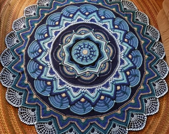 May include: A large, round crocheted mandala with a blue, green, and white color scheme. The mandala has a intricate design with multiple layers of concentric circles.