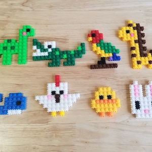 May include: A set of ten colorful plastic animal figurines, including a dinosaur, a crocodile, a parrot, a giraffe, a chicken, a chick, a whale, and a rabbit. The figurines are made of small plastic squares.