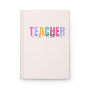 May include: A pink notebook with the word "TEACHER" in rainbow colours and the text "Mrs. Williams" in black cursive.