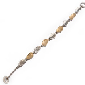 May include: A silver bracelet with a chain and alternating gold and silver oval-shaped links.