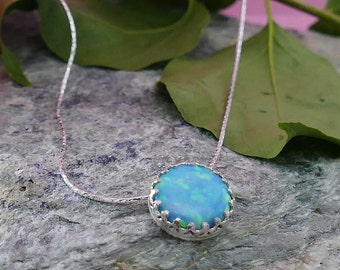 May include: A silver chain necklace with a blue opal pendant set in a silver bezel.