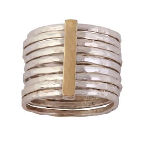 Könnte beinhalten: Ein silberner Ring mit einem goldenen Balkenakzent. Der Ring besteht aus mehreren dünnen Bändern, die übereinander gestapelt sind.
