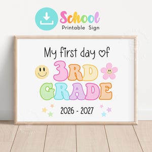 May include: A rectangular printable sign with the text My first day of 3RD GRADE 2026-2027. The design features a yellow smiley face, a pink flower with a smiley face, and colourful pastel stars. The text is in a mix of black and bubble-style letters.