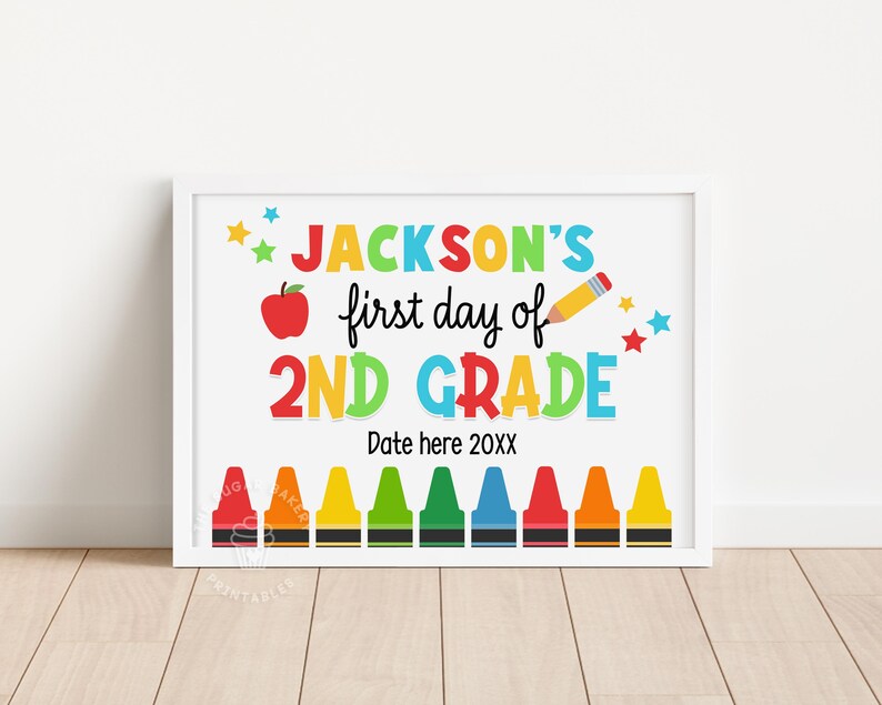 May include: A colorful printable sign that says "JACKSON'S first day of 2ND GRADE" with a red apple, a pencil, and stars. The sign also has a row of crayons at the bottom with the text "Date here 20XX".