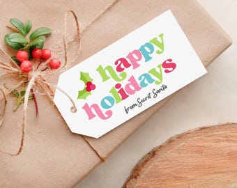 May include: A white gift tag with the words "Happy Holidays" in colorful, retro-style lettering. The tag also features a small green holly sprig with red berries and the text "from Secret Santa".