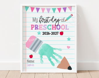May include: A rectangular print on lined paper featuring the text My first day of PRESCHOOL 2026-2027. It includes a teal handprint graphic, a pencil, a red apple, a pink heart, a teal star, and a row of colorful triangular bunting flags.