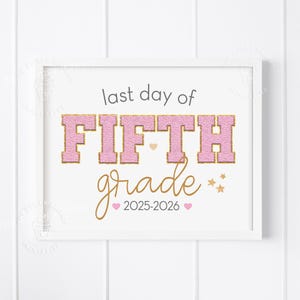 May include: A framed print with the text "last day of FIFTH grade 2025-2026". The words "FIFTH grade" are in pink with a gold outline. The other text is in gold script. The frame is white.