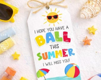 Könnte beinhalten: Ein weißes Geschenk-Etikett mit einer Sonne mit Sonnenbrille und dem Text "Ich hoffe, du hast einen Ball diesen Sommer, ich werde dich vermissen!" umgeben von Stranddekorationen.