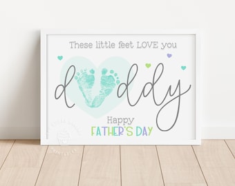 May include: A white card with a blue heart containing two baby footprints. The text reads "These little feet LOVE you daddy Happy Father's Day".