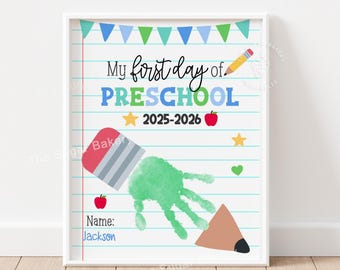 May include: White framed print with the text "My first day of Preschool 2025-2026". Features a green handprint, pencil, eraser, stars, hearts, and apple illustrations. Includes the name "Jackson".
