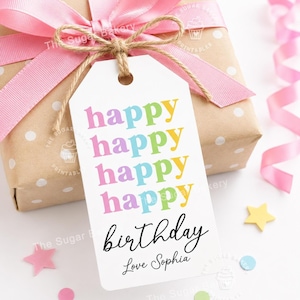 May include: A white rectangular gift tag with rounded top corners, tied with brown twine. The tag features the word happy repeated four times in pink, blue, green, and yellow, followed by the word birthday and Love Sophia in black script.