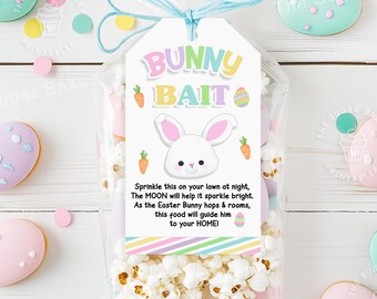 May include: A white tag with the text "Bunny Bait" in rainbow colors and a cartoon bunny rabbit. The tag is attached to a clear plastic bag filled with popcorn. The tag also includes the text "Sprinkle this on your lawn at night, The MOON will help it sparkle bright. As the Easter Bunny hops & roams, this food will guide him to your HOME!"
