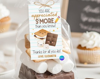 Może przedstawiać: Przezroczysta torebka celofanowa wypełniona piankami marshmallow, krakersami graham i czekoladami. Etykieta przymocowana sznurkiem głosi: "YOU ARE appreciated S'MORE than you know!" i "Thanks for all you do!"