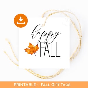 以下が含まれることがあります： 「happy FALL」の文字が黒い筆記体とブロック体で書かれた白い正方形のギフトタグ。オレンジ色の葉のイラストが描かれています。ダウンロードアイコンが左上にあります。タグは紐で結ばれています。