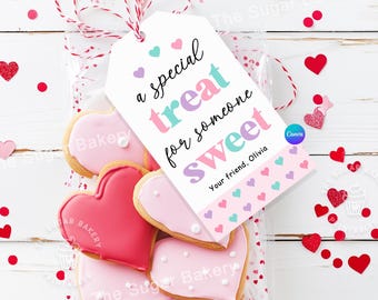 Könnte beinhalten: Ein rosa-weißes Geschenkanhänger mit dem Text "a special treat for someone sweet" in bunten Buchstaben. Der Anhänger ist mit rosa, blauen und violetten Herzen und dem Text "Your friend, Olivia" verziert.