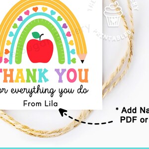Op de afbeelding: Een vierkant label met een regenboog, appel en potlood ontwerp. De tekst luidt "THANK YOU for everything you do From Lila". Het label is vastgebonden met touw, voor een cadeau of kaart.