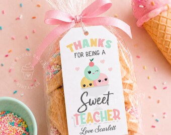 May include: A clear cellophane bag tied with a pink ribbon, containing cookies and a tag that reads "Thanks for being a Sweet Teacher, Love Scarlett." A pink ice cream cone and a bowl of sprinkles are also visible.