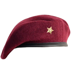 May include: A maroon beret with a gold star badge. The beret has a black leather band around the bottom edge.
