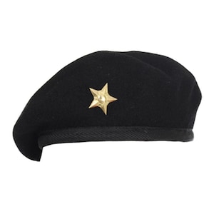 Puede incluir: Un gorro negro de lana con un emblema de estrella dorada.