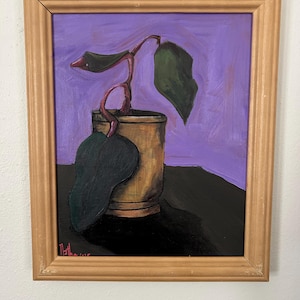 Może przedstawiać: Oryginalny obraz przedstawiający roślinę w złotym pojemniku na fioletowym tle. Dzieło sztuki jest oprawione w jasnobrązową drewnianą ramę. Roślina ma zielone liście i czerwonobrązową łodygę.