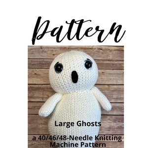 May include: Knitting pattern for a large ghost, a 40/46/48-needle knitting machine pattern. The pattern is for a white ghost with black eyes and a black mouth. The ghost is sitting on a wooden surface. "Large Ghosts" and "An Orange-Olive Road Design" are written on the image.