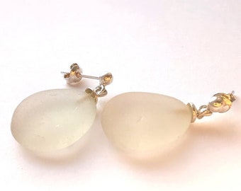 Puede incluir: Un par de pendientes de plata y oro con piedras de cristal transparente en forma de lágrima.