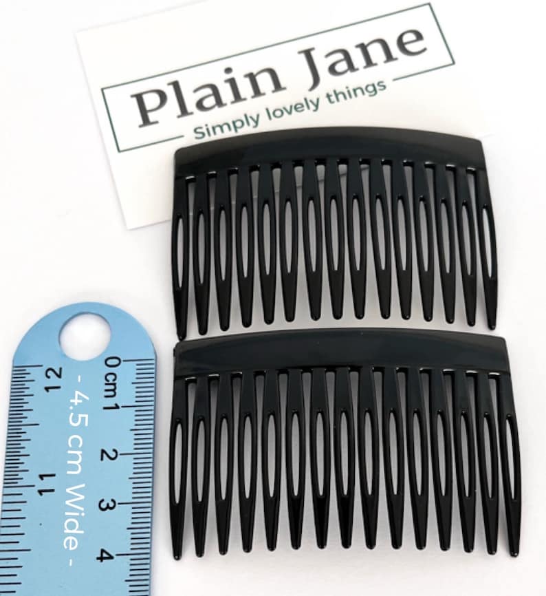 May include: Two black hair combs with fine teeth, next to a ruler showing a width of 4.5 cm. The combs are made of a glossy material. The text "Plain Jane Simply lovely things" is visible in the background.