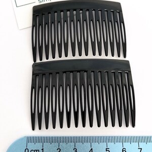 May include: Two black hair combs, each with a curved top and multiple teeth. The combs are 7 cm long. The image includes the text "Plain Jane Simply lovely things".